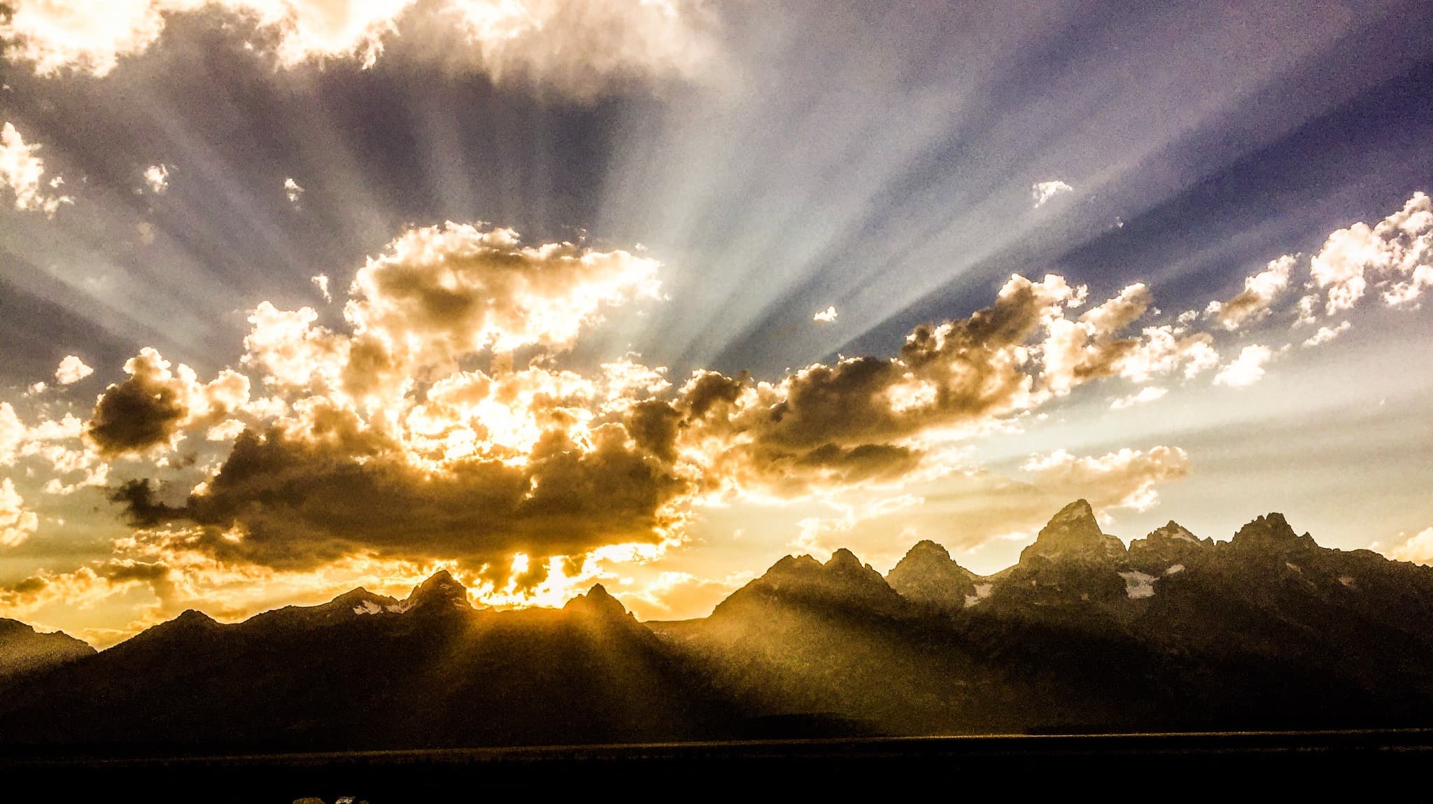 Sunbeams breaking through clouds above the Teton Range